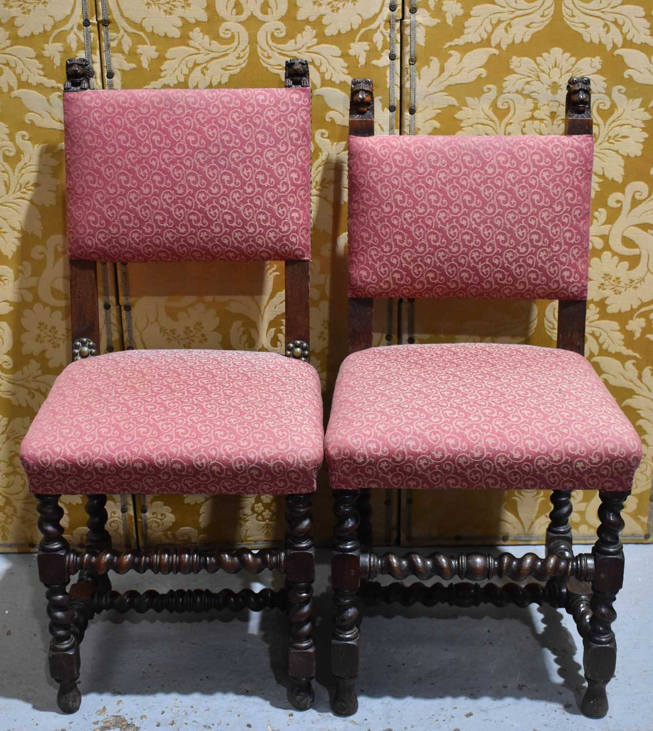 A near pair of 19th century oak hall chairs, each carved with lion head finials, and having barley