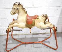 A vintage tin plate rocking horse, the horse suspended on springs and a steel frame.