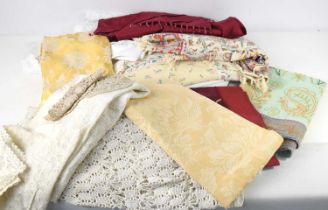A collection of vintage fabrics to include embroidered cloths, lace place mat and table cloths and