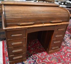 A 1930s oak roll top desk with tambour slide.