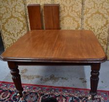 A Victorian mahogany dining table with two extra leaves and original winder, raised on lobe carved