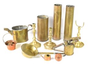 Three brass shells together with a brass pan, two brass candlesticks, Optimus brass blowtorch and