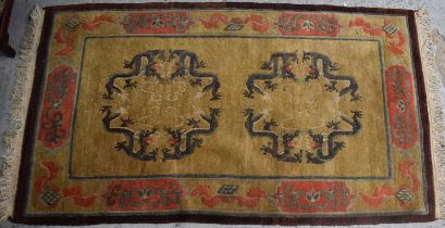 A Chinese wool rug, depicting dragons on a yellow ground, 165 by 94cm.