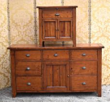 A pine sideboard with seven drawers and central cupboard, 173cm by 152cm by 60cm, together with a