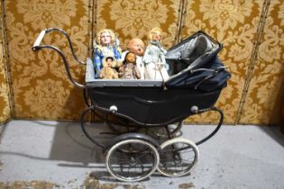 A vintage Marmet coach built dolls pram together with a group of dolls.