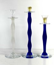 Three Orrefors of Sweden glass candlesticks by Celeste Anne Nilsson, two with blue opaque stems, the