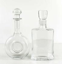 Two Kosta Boda clear glass decanters, both with the original stoppers, one of 'doughnut' form,