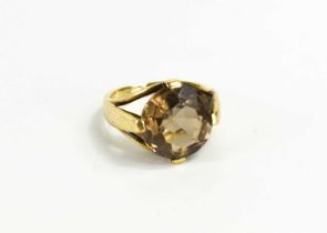 A 9ct gold and smokey quartz dress ring, the circular facet cut quartz in a modern style setting,