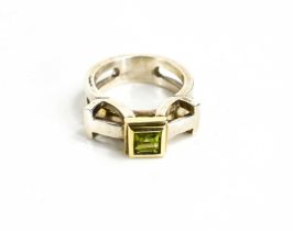 A silver and parcel gilt ring, set with an emerald cut peridot, by jewellery designer Christopher