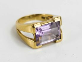 A 9ct gold and amethyst set dress ring, the emerald cut amethyst set in V-cut shoulders, size K, 5.