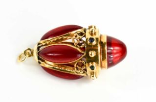 A gold egg form pendant, set with red gemstone cabochons, 3.5cm to the top of the hoop, unmarked but