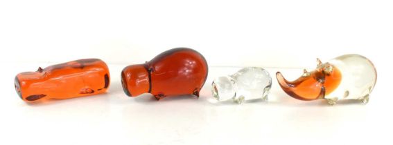 A group of three Wedgewood, Kings Lynn glass hippos, comprising a large amber hippo, 7cm high, a