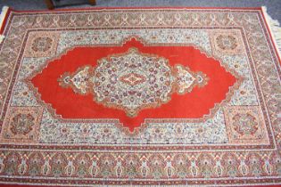 A Turkish Wool Touch Acrylic machine woven rug, with central medallion on red ground and deep border