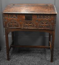A 17th century oak bible box on stand, the plank lid opens to reveal three small interior drawers,