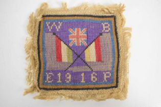 A WWI needlework, with a union flag on purple ground above two crossed flags, with W. B. E. P to the