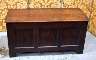 An 18th century oak coffer with three panel front, the interior having a candle box, raised on stile