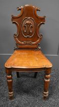 A Victorian carved hall chair with scrolling shield back, 44 by 40 by 89cm high, seat height 44cm.