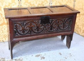 A 17th century oak coffer, the three panel lid above a single panel carved with Fleur-de-lis, raised