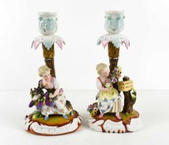 A pair of 19th century Sitzendorf porcelain candlesticks, of figural form, each with a young girl to