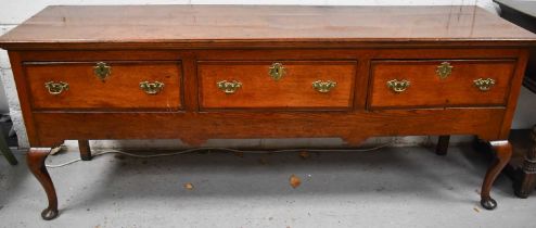 An 18th century George III sideboard, or dresser base, with three drawers, the centre one baize