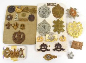 A group of military cap badges and shoulder titles to include Cameron Highlanders, 14th/20th