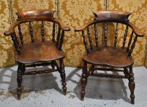 Two elm Smokers bow chairs with swept scroll crest rails.