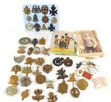 A group of military cap badges including The Border Regiment, The Cambridgeshire Regiment, The Essex