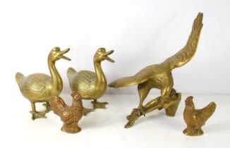 A large brass eagle ornament together with brass ducks and cockerels.