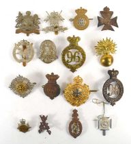 A collection of military cap badges to include Manchester Regiment, Scots Guards officers forage cap