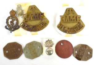 A group of identity tags and cap badges, including two cap badges for the Royal Army Medical