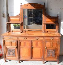 An antique Maple & Co oak mirror back sideboard having a large bevelled edge mirror to the centre,