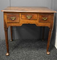 A 17th century oak lowboy, with three short drawers to the front, raised on tapered legs with pad