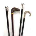 A group of vintage walking canes, two having silver handles, the other having a handle in the form