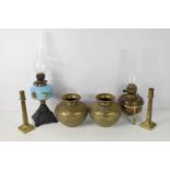 Two antique oil lamps, one example by Duplex, together with a pair of brass column form candlesticks