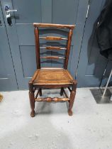 A Georgian elm ladderback chair with turned front stretcher and legs.