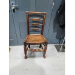 A Georgian elm ladderback chair with turned front stretcher and legs.