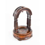 A 19th century Georgian oak pocket watch stand, of arch form raised on turned pillars and circular
