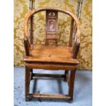 An antique Chinese hardwood arm chair with shaped and carved decorative splat, legs united by