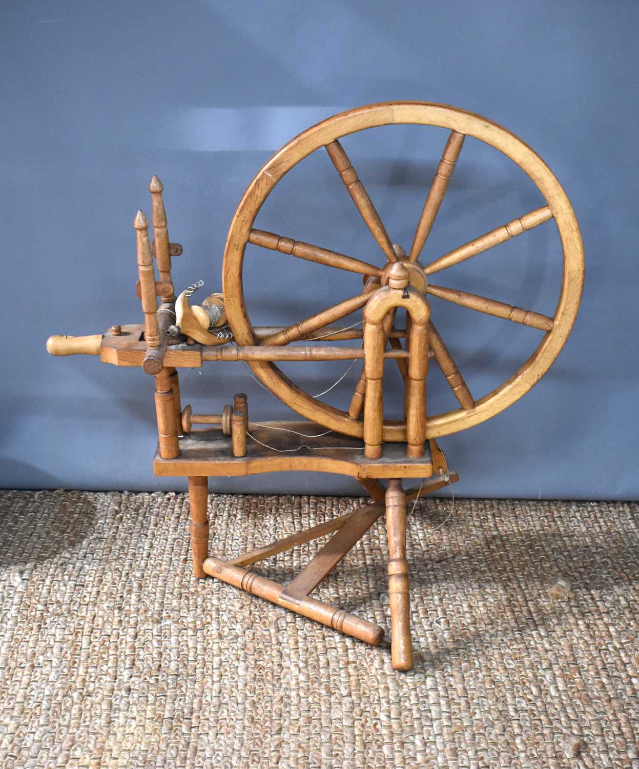 An antique pine spinning wheel, 100cm. [Provenance: The Estate of Cressy Hall, Lincolnshire. This