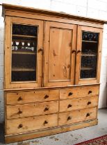 An antique pine Housekeepers’ cupboard, the central door flanked by two glazed cupboard doors