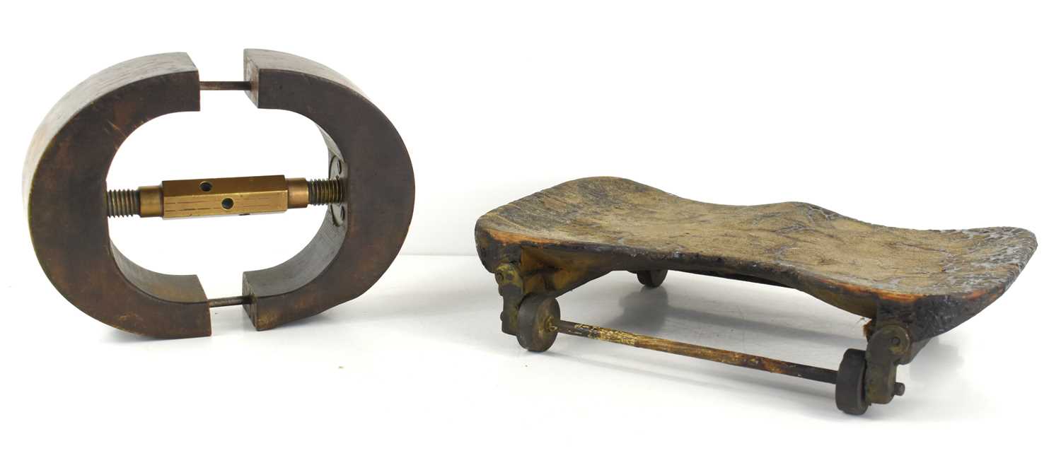 A vintage wood and brass hat band stretcher together with a wooden seat on wheels.