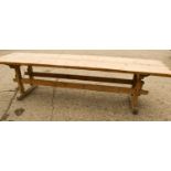 A large pine country trestle table with long planked top above a double stretcher base, 298cm by