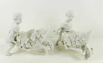 A pair of blanc de chine putti figurines, pushing leaf form wheel barrows, likely Triebner Ens &