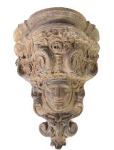 A 19th century cast iron corbel in the form of a face mask within a cartouche, 37cm.