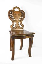 A 1920s childs musical chair, the shaped and carved decorative back having a shaped seat which