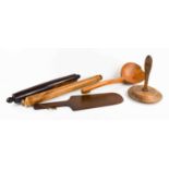 A selection of 19th century treen to include a pine vegetable press, a mahogany bakers peel, a