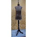 An antique seamstress mannequin raised on an ebonised tripod base, 171cm high.