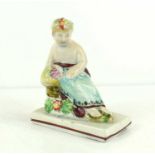 An early 19th century Staffordshire Pearlware figure of a seated girl holding a basket of fruit, 8cm