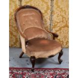 A Victorian mahogany button back nursing chair raised on scroll knop feet with castors.