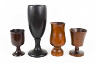 A group of four treen goblets, to include a hardwood example with abstemious depth, a large ebony